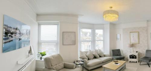 a living room with a couch and a chandelier at Spacious 4 Bed Victorian House with Sea Views in Ilfracombe