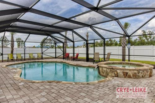 a pool in a pavilion with chairs and tables at The Big Kahuna in Foley