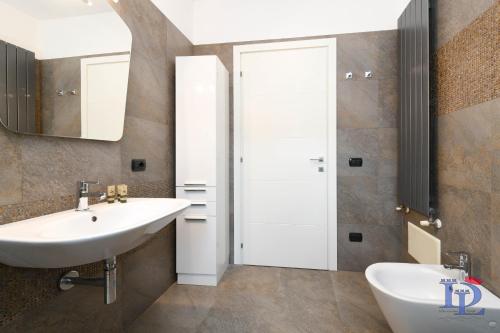 W łazience znajduje się umywalka i lustro. w obiekcie Desenzanoloft The Wind Rose w mieście Desenzano del Garda