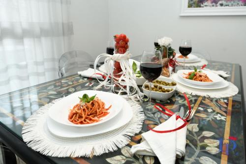 einen Tisch mit Pastagerichten und Gläsern Wein in der Unterkunft Marriott The Wind Rose renovation 2025 DesenzanoLoft Official Partner Homes & Villas by Marriott Bonvoy in Desenzano del Garda