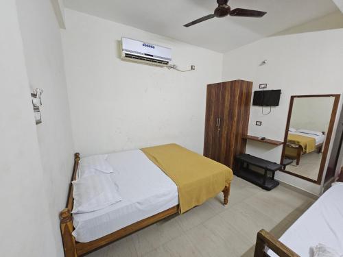 a bedroom with a bed and a mirror at Raja Rani Mahal & Residency in Tiruvannāmalai