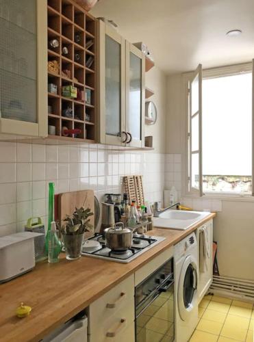 une cuisine avec un évier et une cuisinière four supérieur dans l'établissement A haven of peace in Pigalle, à Paris