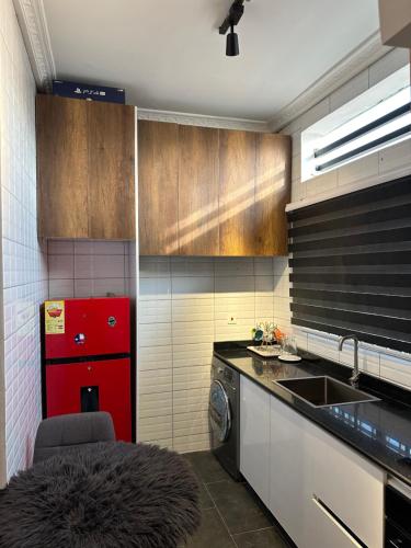 a kitchen with a red refrigerator and a sink at Rich homes in Baatsona