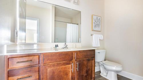 een badkamer met een wastafel, een toilet en een spiegel bij Landing Modern Apartment with Amazing Amenities (ID9174X16) in Fredericksburg