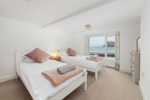 zwei Betten in einem Zimmer mit Meerblick in der Unterkunft Seaview on the beach in Port Erin