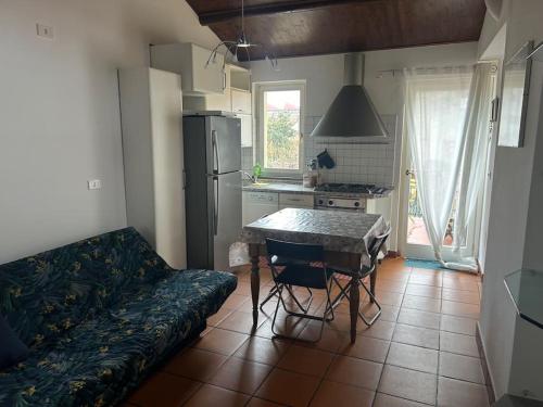 een keuken met een bank, een tafel en een koelkast bij Studio Cento3Cento - Holiday & Business Apartment in Bologna