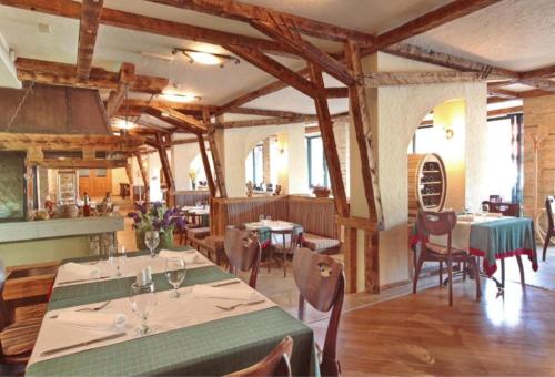 a dining room with tables and chairs and wooden ceilings at Kraljevi Konaci Olja in Zlatibor