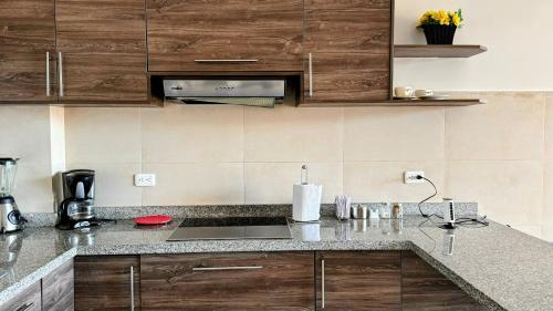 a kitchen with wooden cabinets and a sink at Edificio Tofino in Quito