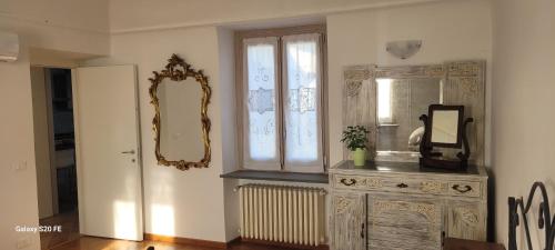 Pokój z komodą z lustrem i oknem w obiekcie Il giardino di Marianna w mieście Novi Ligure
