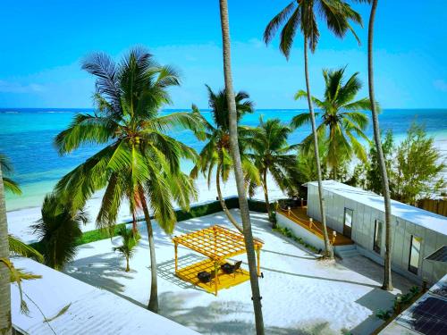 uitzicht op het strand vanaf het balkon van een resort bij The Zanzibar Beach House-South in Bwejuu