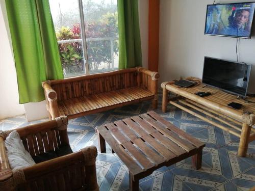 Elle comprend un salon doté d'un mobilier en bois et d'une fenêtre. dans l'établissement Rest House Vista al Mar, à Puerto López