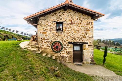 Una casa de piedra con una corona de Navidad. en Casa rural La alemana, en Liérganes