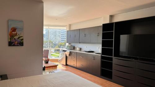 a kitchen with a large flat screen tv on the wall at Edificio Tofino in Quito