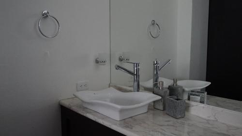 a bathroom with a white sink and a mirror at Edificio Tofino in Quito