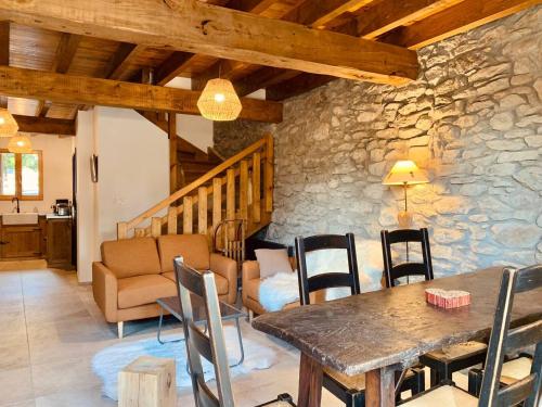 uma sala de estar com uma mesa de madeira e cadeiras em Charmante Maison de village: Prestation de Qualité, Tout confort, Terrasse em Targassonne