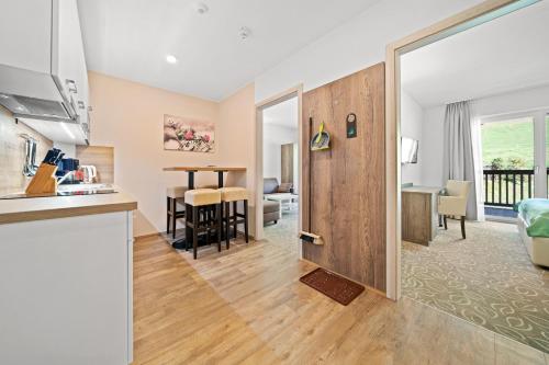 a kitchen and a living room with a table at Landhotel Berger in Eben im Pongau