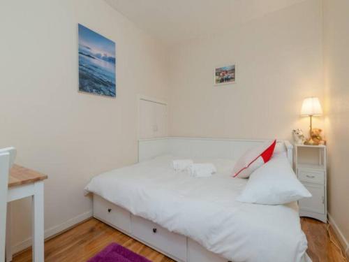 a white bedroom with a bed and a desk at Pass the Keys Spacious Murrayfield Flat in Edinburgh