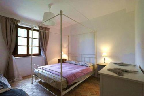 a bedroom with a canopy bed and a desk at Agriturismo Tenute di Hera - Via Francigena in Acquapendente