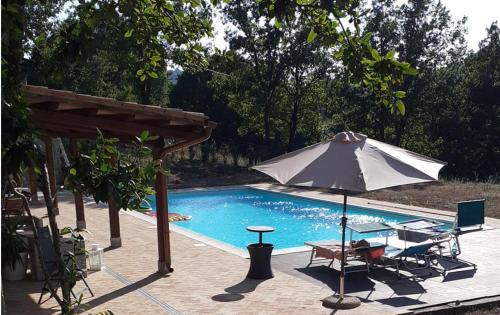 una sombrilla sentada junto a una piscina en Agriturismo Tenute di Hera - Via Francigena, en Acquapendente