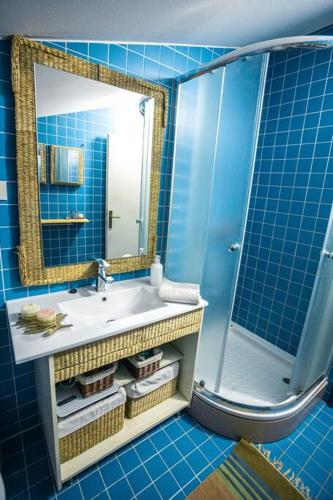 a blue bathroom with a sink and a mirror at tabiacondo in Ljubuški