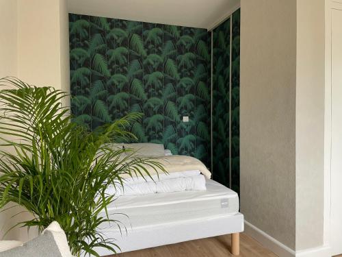 a bedroom with a wall with green wallpaper at Le P’tit B - Quartier Saint-Michel/Centre Ville in Saint-Brieuc