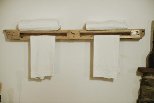 two towels on a wooden shelf on a wall at A casa di Sole Brovello in Brovello-Carpugnino