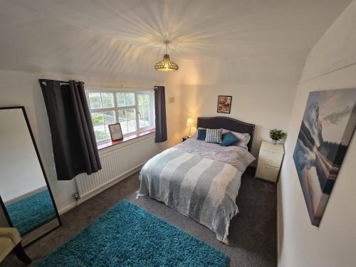 a bedroom with a bed with a blue rug at Beautiful 4 bedroom house 7 minutes from Luton Airport in Luton