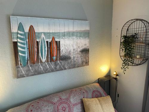 1 dormitorio con tablas de surf colgadas en la pared en Charmant Studio Camargue Village 150 m de la plage, en Le Grau-du-Roi