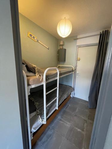 Cette chambre lumineuse comprend des lits superposés. dans l'établissement Charmant Studio Camargue Village 150 m de la plage, au Grau-du-Roi