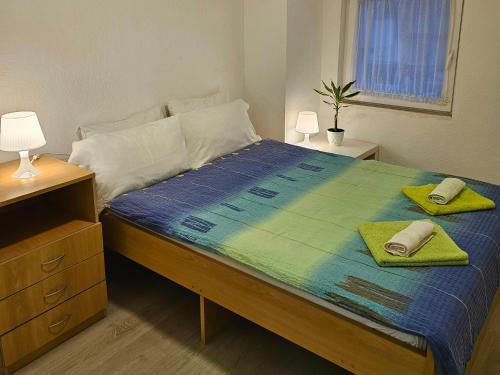 een slaapkamer met een bed met twee handdoeken erop bij My Parents Guest House in Petrovec