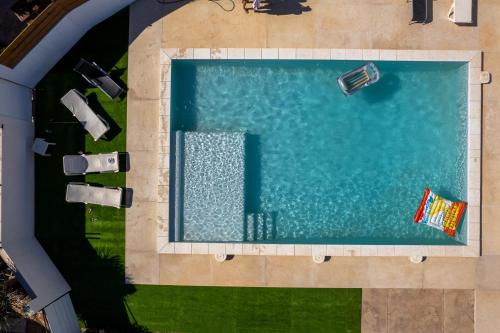 an overhead view of a swimming pool with chaise lounges at VILLA MAR in Cala'n Bosch