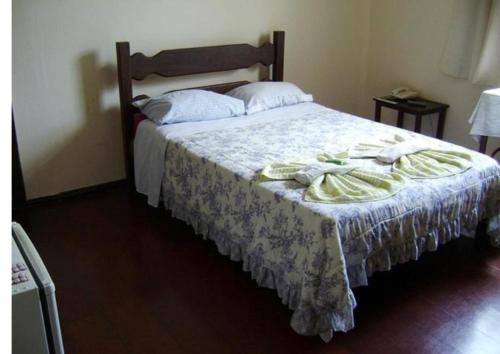 a bedroom with a bed with towels on it at Pousada Villa Real in Sabará