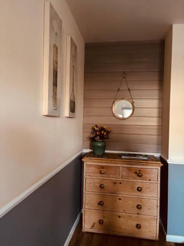a room with a wooden dresser and a mirror at Chambres Dhôtes Numéro 1 in Châteaulin