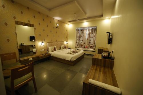 Habitación grande con cama y espejo. en The Kumbha Mahal Resort, en Kumbhalgarh