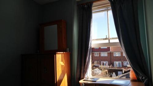 a room with a window with a view of a building at Cosy London single room (near Wimbledon) in London