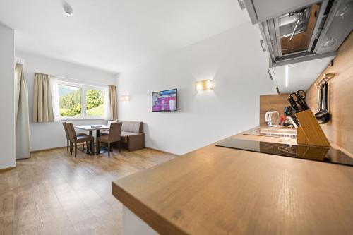 a kitchen and a living room with a table in a room at Landhotel Berger in Eben im Pongau