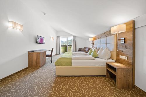 a hotel room with a bed and a desk at Landhotel Berger in Eben im Pongau