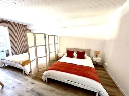 a bedroom with two beds with red pillows at Cosy appartement centre Cusset in Cusset