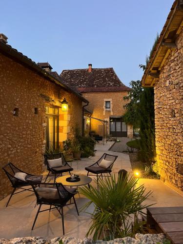 a patio with chairs and a table in a courtyard at Le Clos 1855 in Saint-Laurent-des-Bâtons