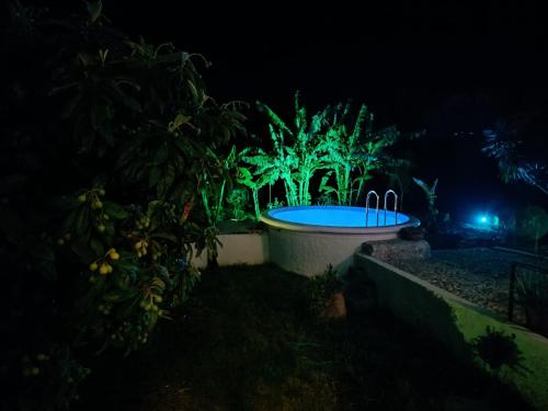 - Vistas nocturnas a una piscina con luces verdes en Azalea garden appartment with mountain view, en Kremasti