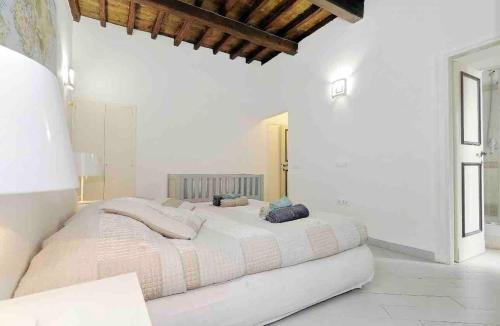 una grande camera da letto bianca con un grande letto con cuscini di terrazza del pontefice a Roma