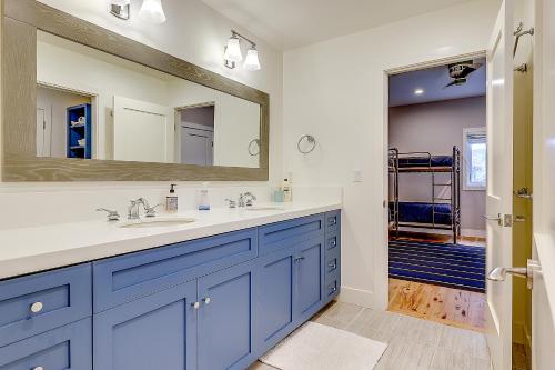 a bathroom with blue cabinets and a large mirror at Tranquil Santa Rosa Home with Private Pool and Views! in Santa Rosa