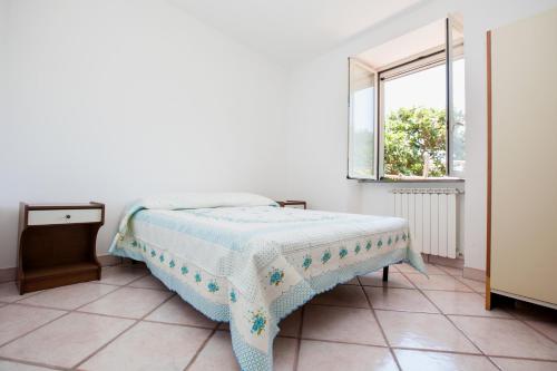 a bed in a white room with a window at Casa Ferrigno in Maiori