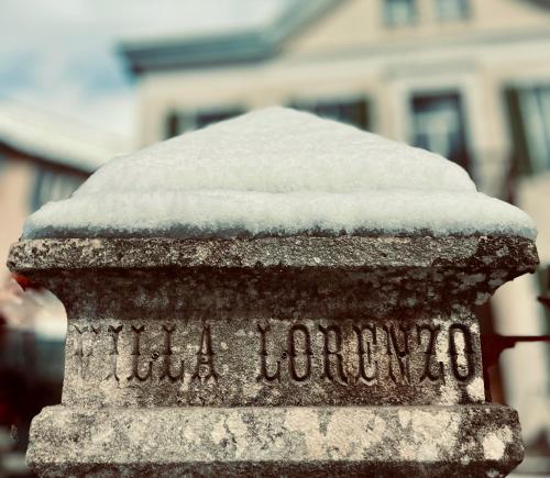 pomnik pokryty śniegiem z budynkiem w tle w obiekcie Villa Lorenzo – Chambres & Restaurant – Barcelonnette w mieście Barcelonnette