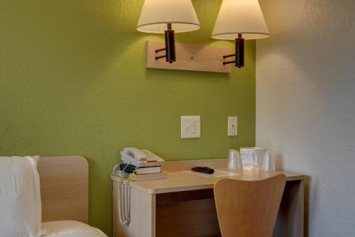 a room with a desk with two lamps on a green wall at Motel 6-Springfield, OR - Eugene North in Springfield
