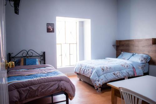 1 dormitorio con 2 camas y ventana en Hospedaje Tel Aviv, en Ayacucho