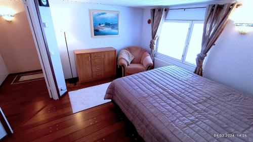 - une chambre avec un lit, une chaise et une fenêtre dans l'établissement Kotka House, à Kotka