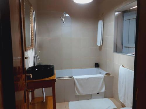 a bathroom with a bath tub and a sink at Village NDJIKESSI in Yaoundé