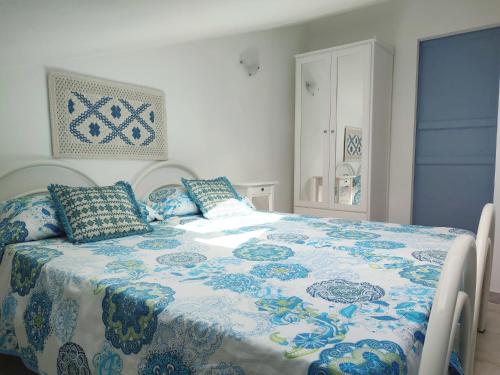 una camera con letto blu e bianco con cuscini di ApartSea 26 a Calasetta