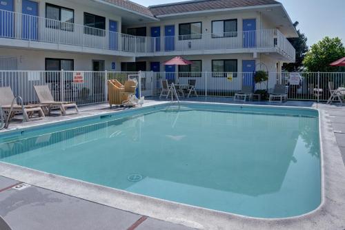a large swimming pool in front of a building with a hotel at Motel 6-Springfield, OR - Eugene North in Springfield